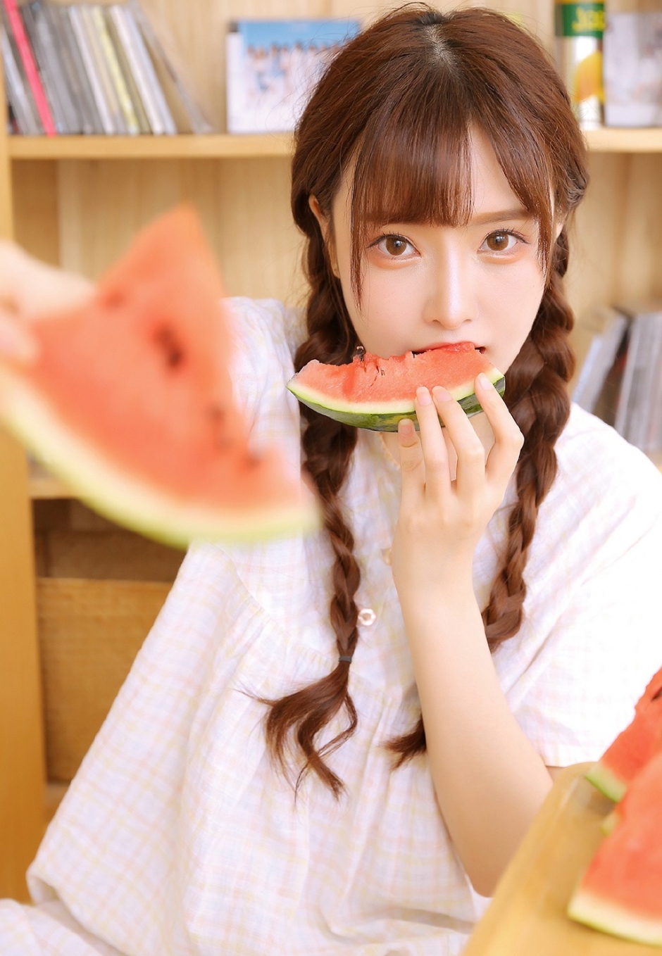 白丝长腿美女俏皮麻花辫眨眼卖萌抿嘴甜笑吃西瓜图片