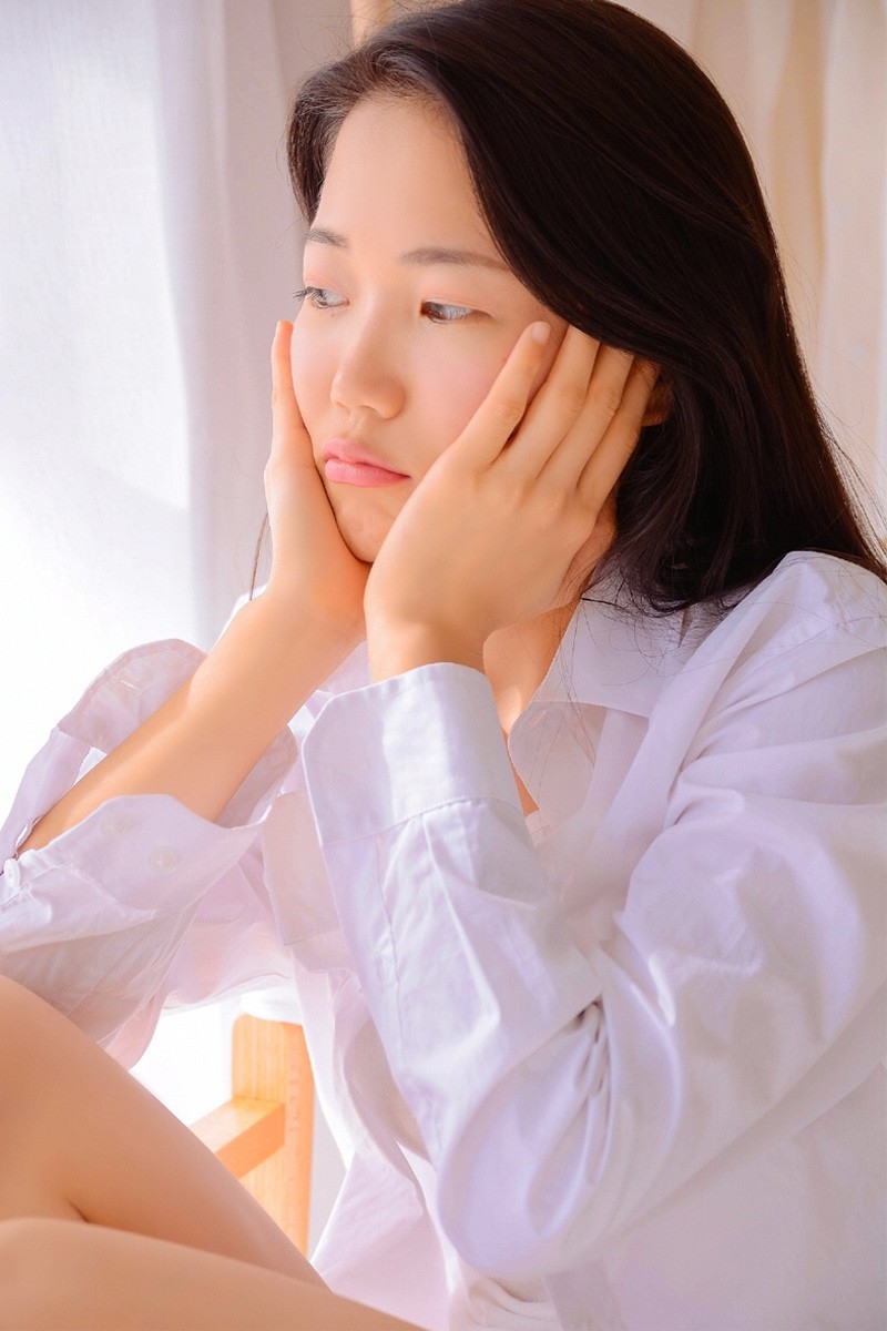 白衬衣美女单眼皮小眼睛脸部骨骼线条硬朗曲腿盘坐图片