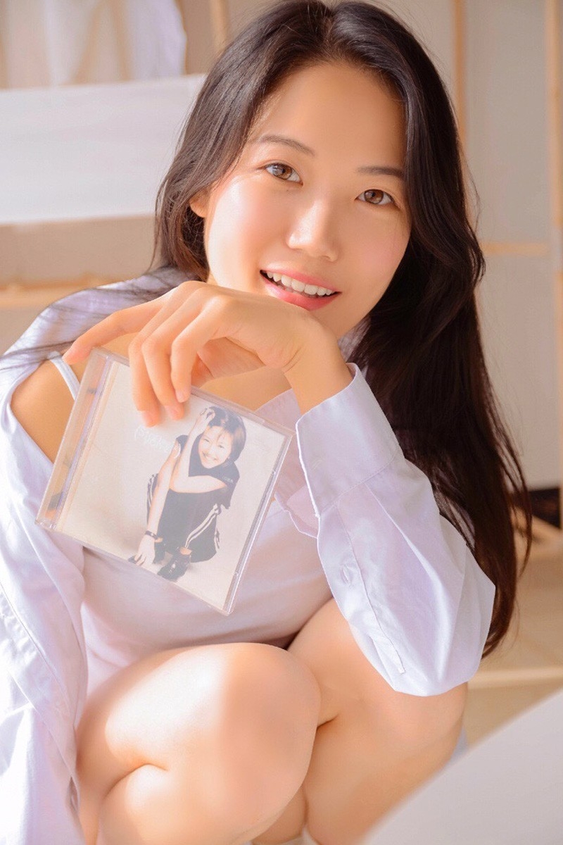 白衬衣美女单眼皮小眼睛脸部骨骼线条硬朗曲腿盘坐图片