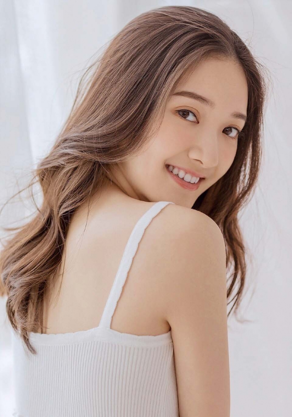 长发披肩美女露齿大笑吊带短裤秀骨感身材打电话图片