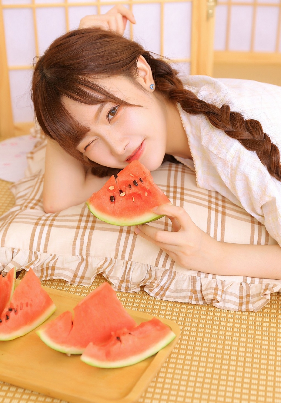 白丝长腿美女俏皮麻花辫眨眼卖萌抿嘴甜笑吃西瓜图片