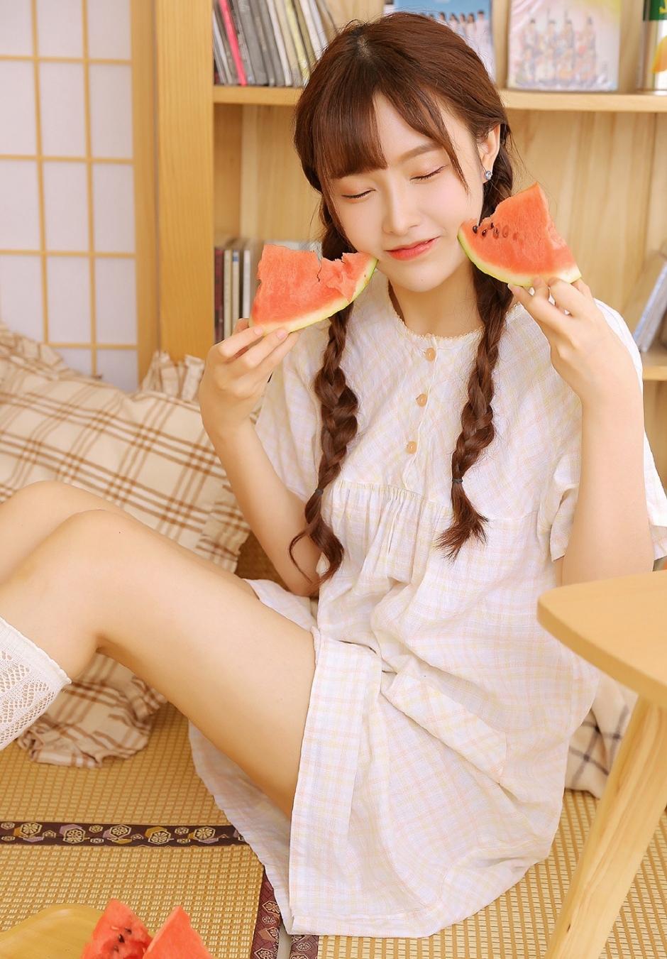 白丝长腿美女俏皮麻花辫眨眼卖萌抿嘴甜笑吃西瓜图片