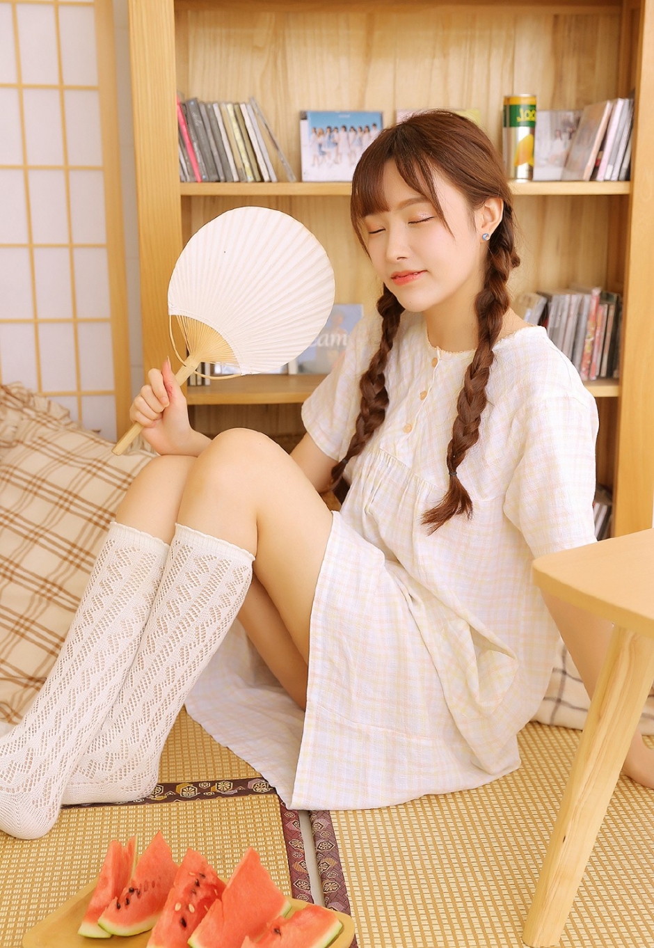 白丝长腿美女俏皮麻花辫眨眼卖萌抿嘴甜笑吃西瓜图片